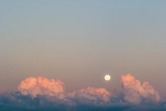 Illustration of moon phases over a calm landscape with soft pastel colors.