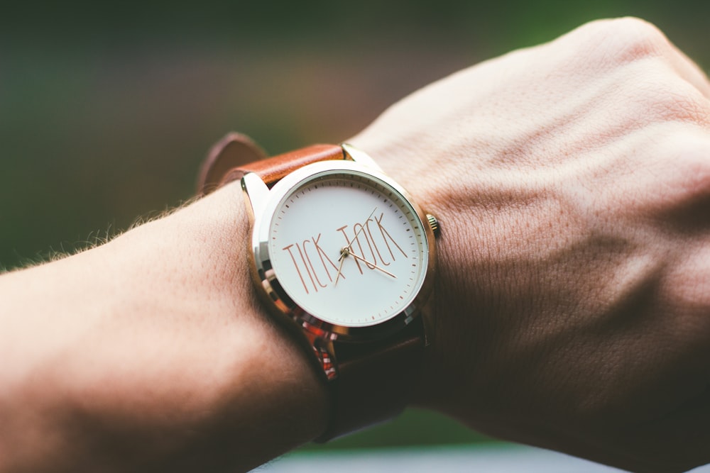 person wearing silver and white analog watch