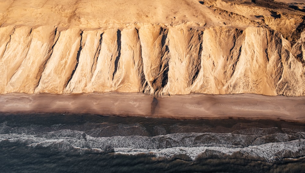 brown rock formation beside body of water during daytime