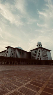 A serene view of the Daruchchunnah Kamil (M.A) Madrasa campus at sunrise, highlighting its modern architecture.