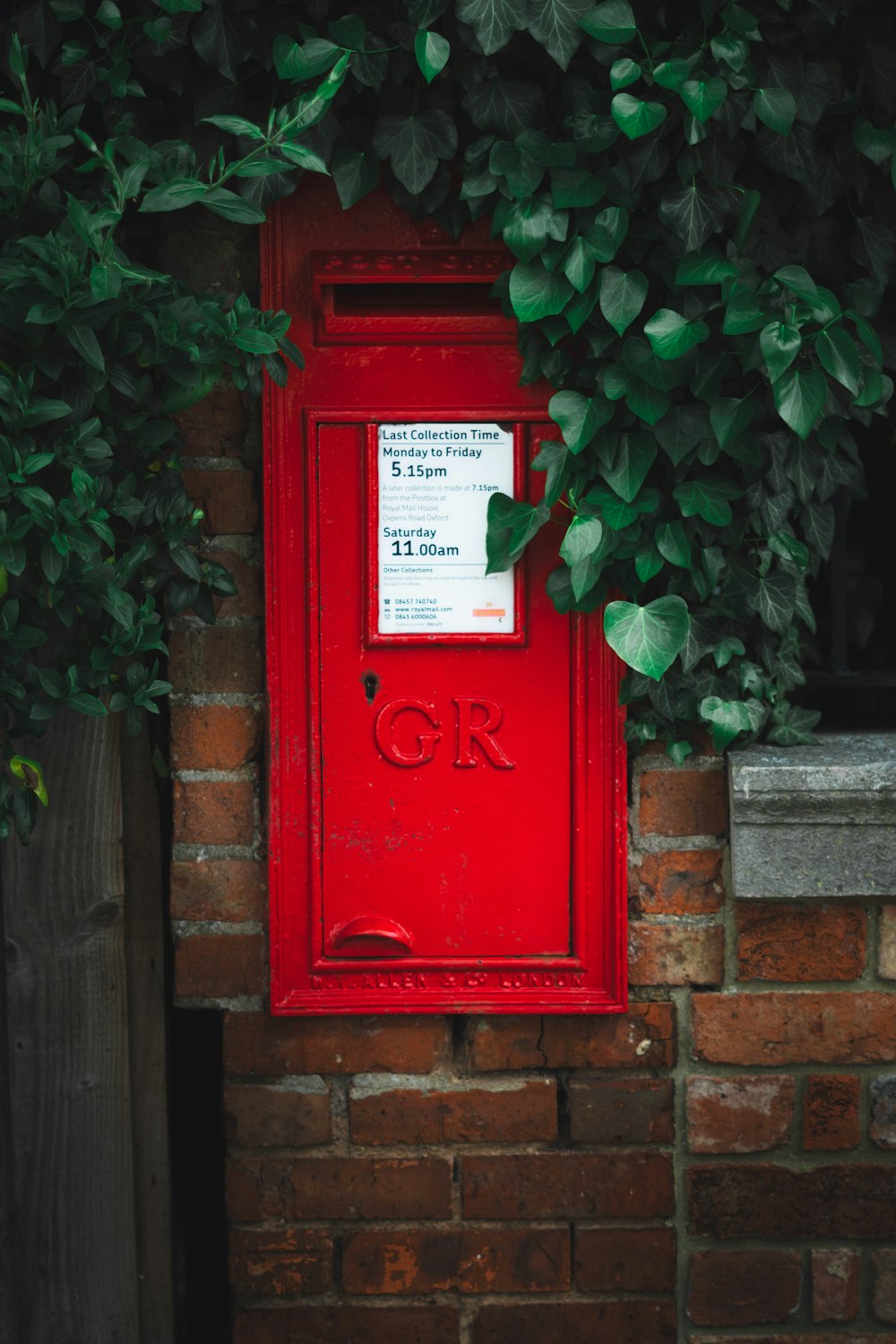 茶色のレンガの壁に赤い郵便ポスト