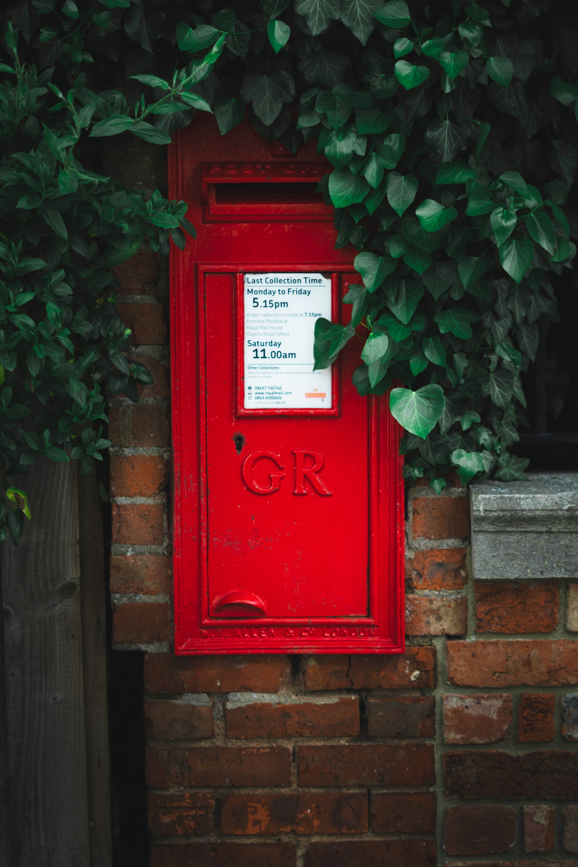 red mail box on brown brick wall