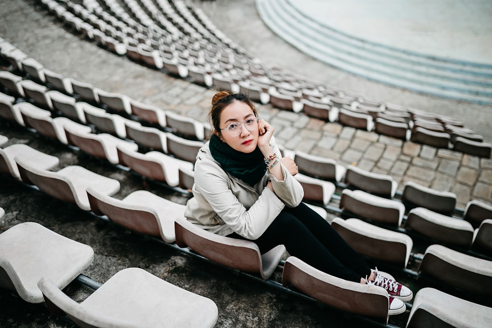 woman in black and white dress sitting on gray and black stadium bench