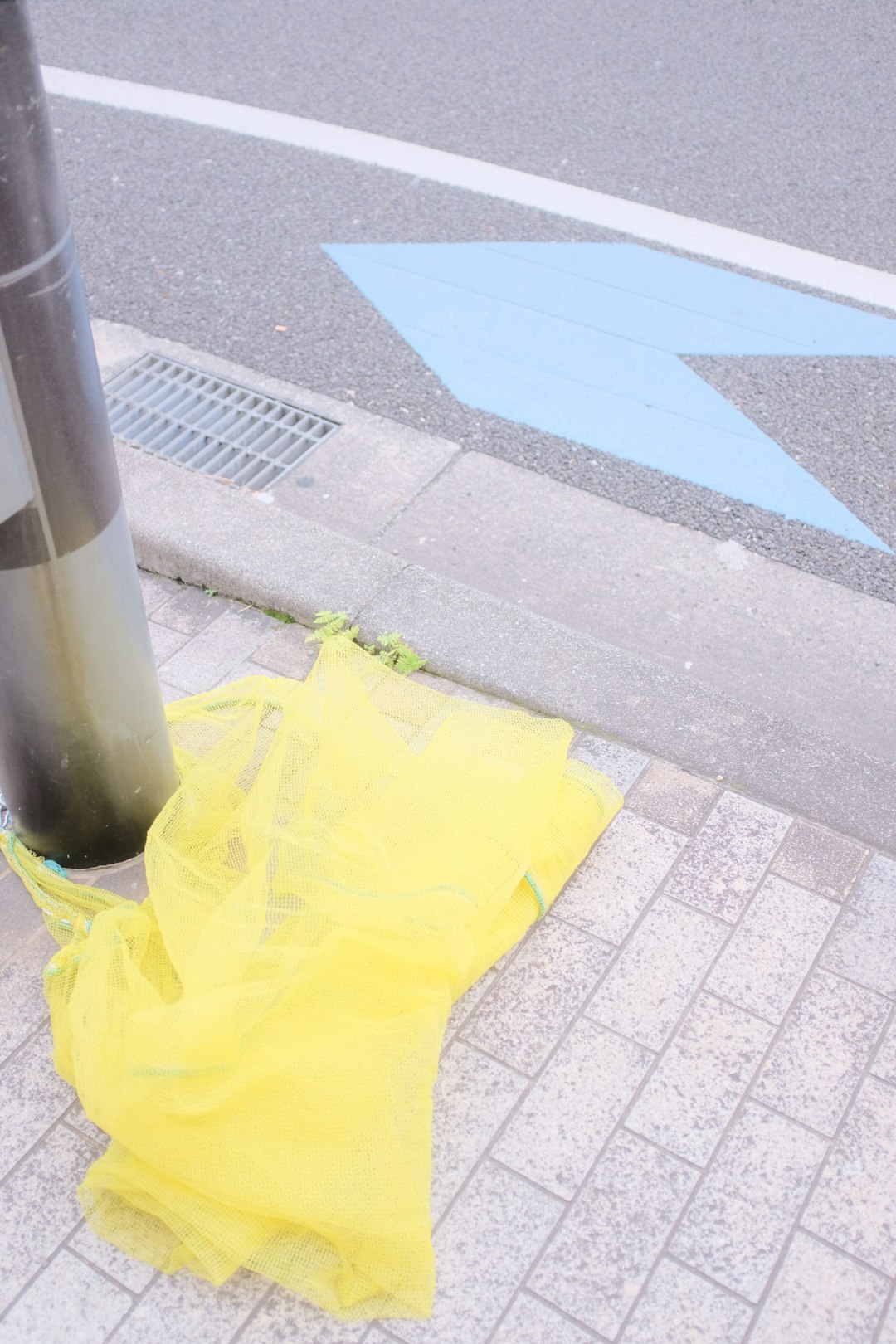 yellow plastic bag on gray concrete road