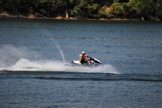 Close-up of a jet ski rider splashing water as they speed across the lake