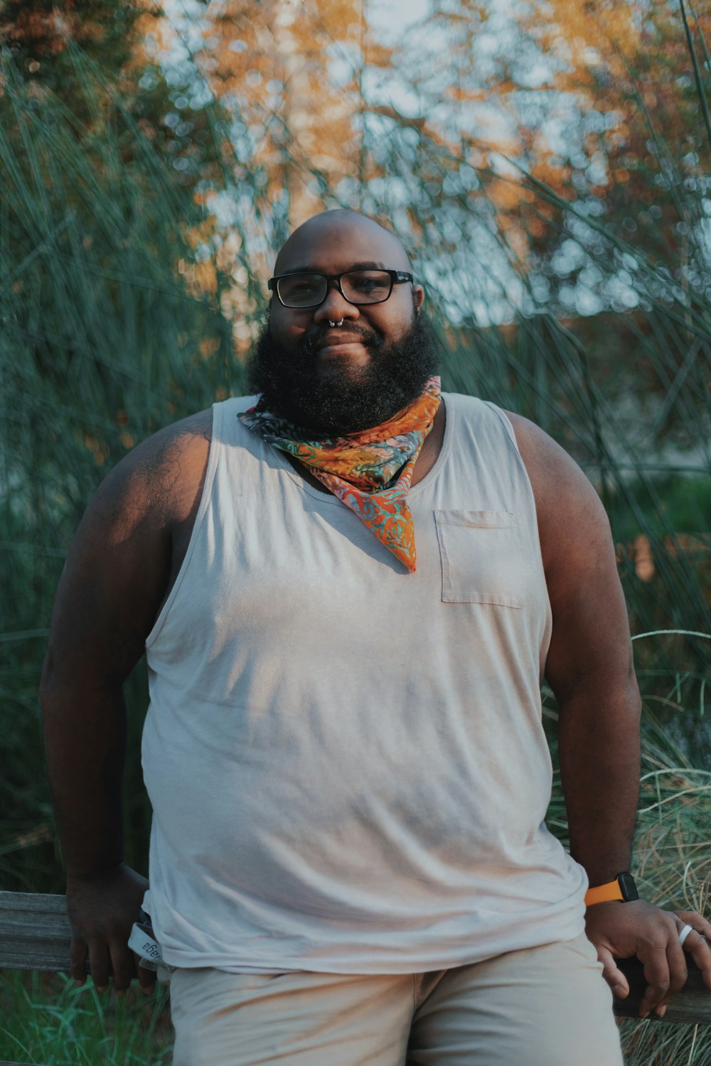 man in white tank top with orange and blue scarf