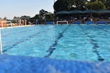 A wide shot of the academy’s outdoor pool area with families watching and cheering
