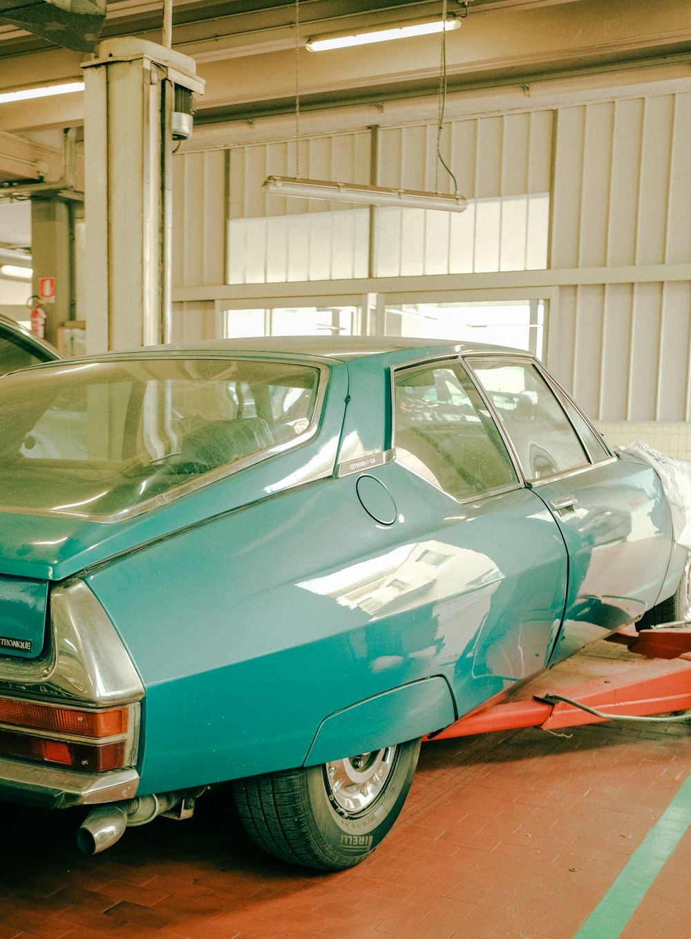 teal car parked in garage