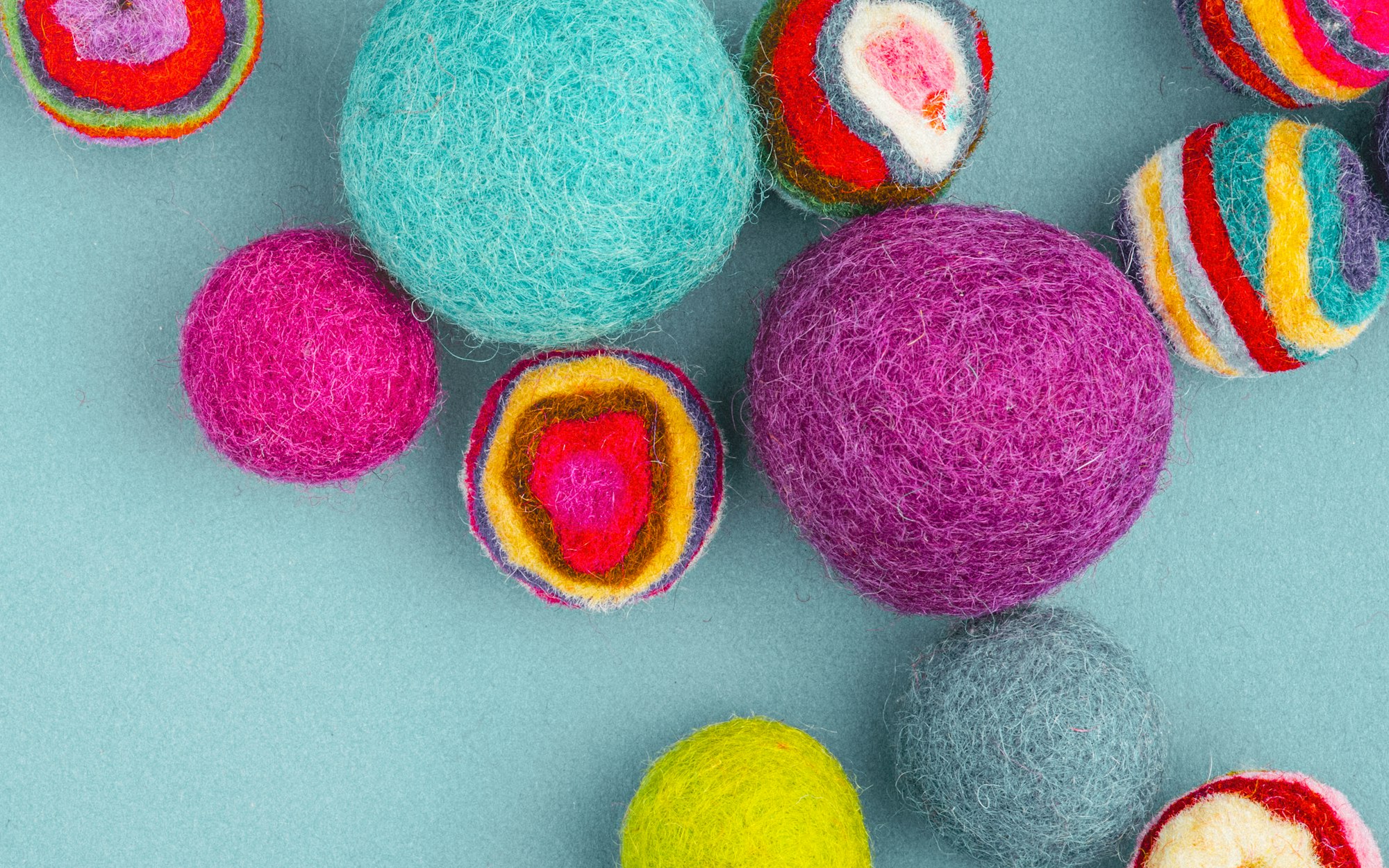 Rainbow wool puffs on a plain background