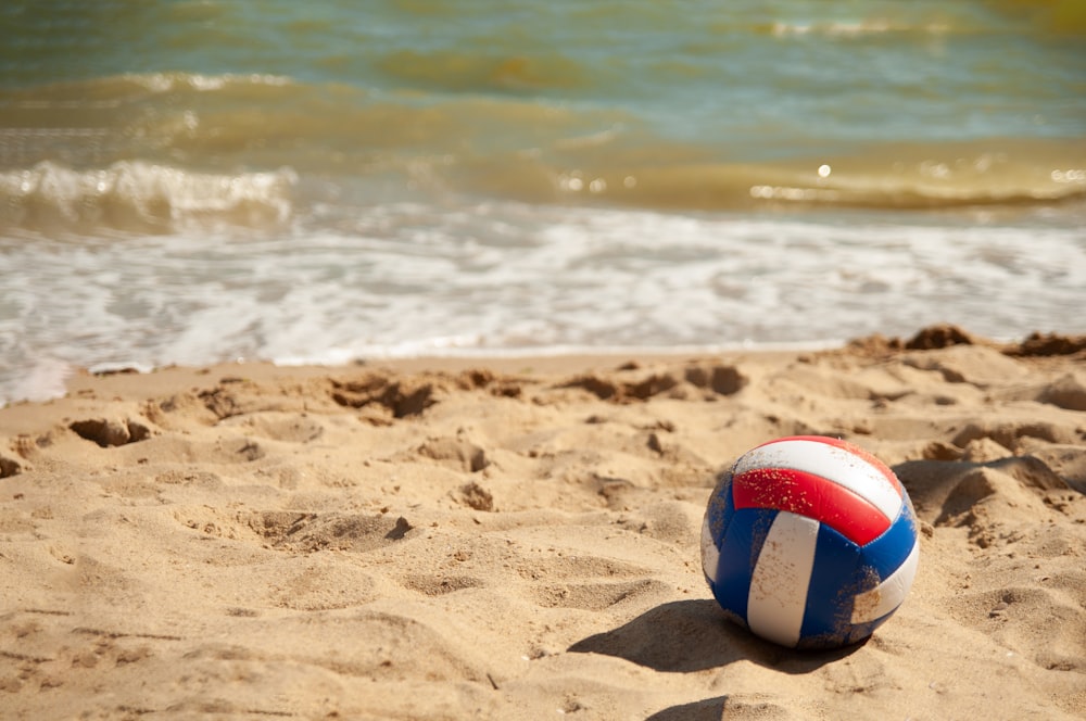 white red and blue beach volleyball on beach during daytime