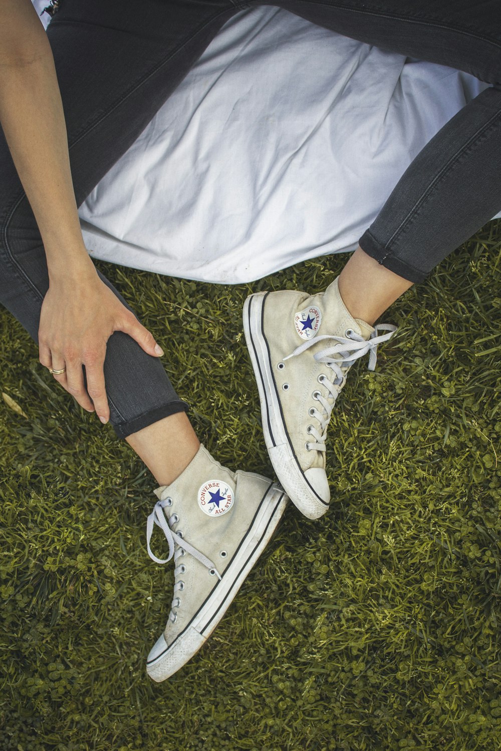 Persona que lleva zapatillas blancas Converse All Star Low Top