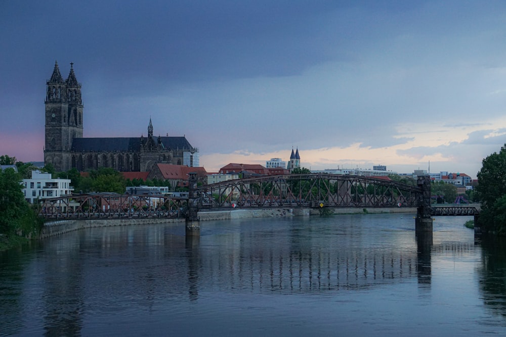 body of water near bridge and buildings during daytime