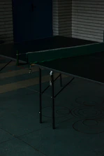 Guests laughing and playing table tennis under soft café lighting.