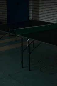 Guests laughing and playing table tennis under soft café lighting.