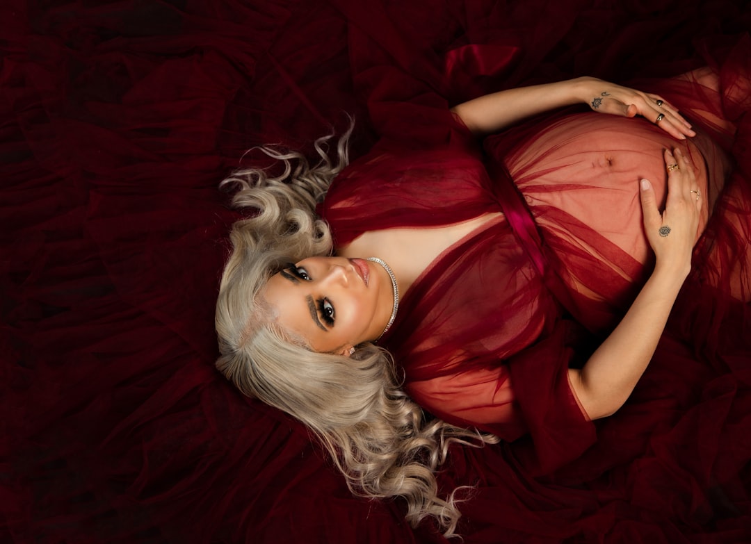 woman in red dress lying on red textile