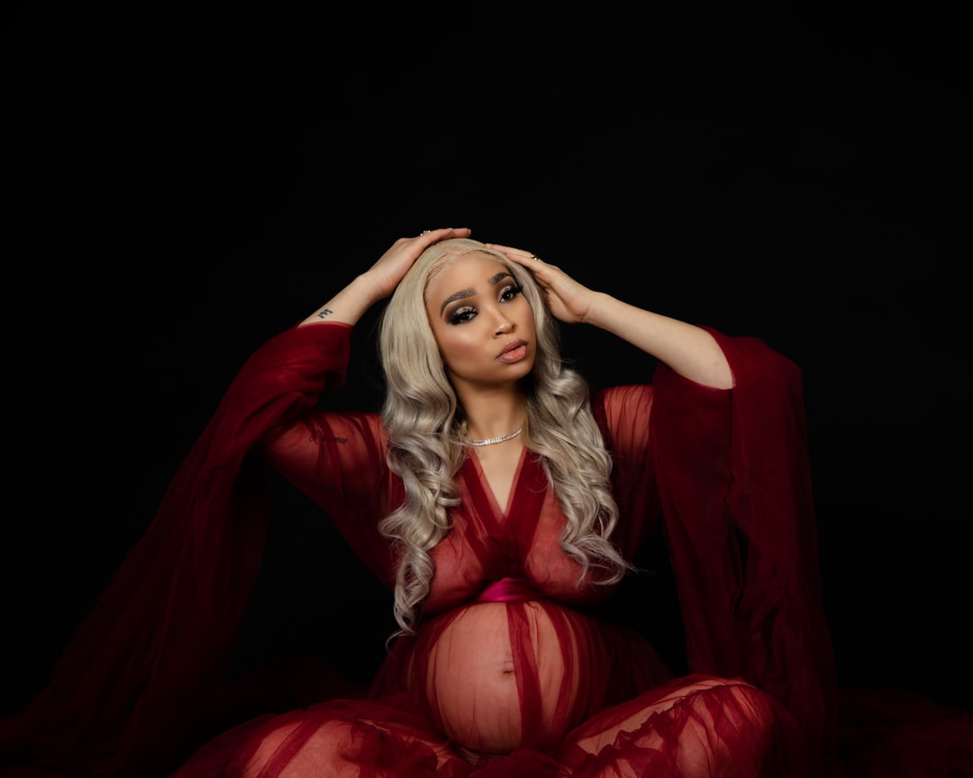 woman in red dress sitting on black background