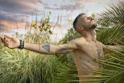 man in black bracelet and black bracelet on green grass field during daytime