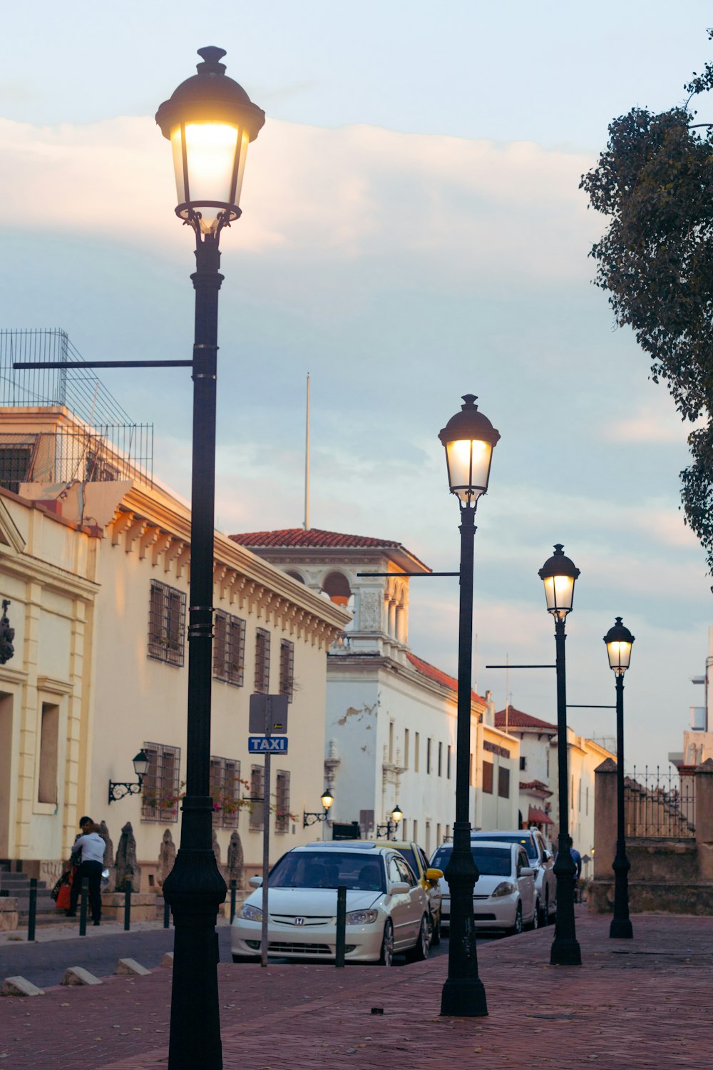 Personas que caminan por la calle cerca de automóviles y edificios durante el día