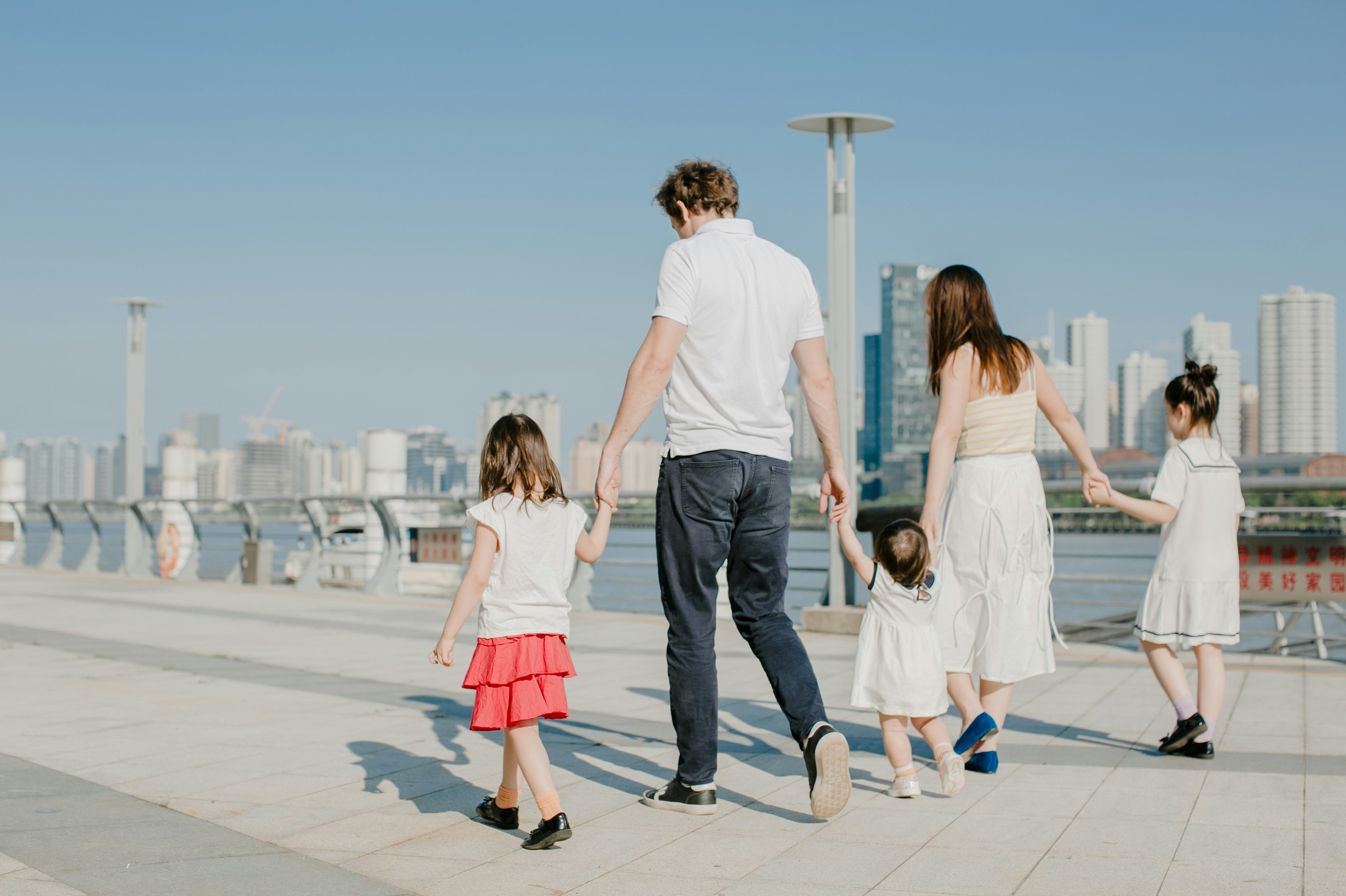 man in white t-shirt and woman in white t-shirt walking on sidewalk during daytime