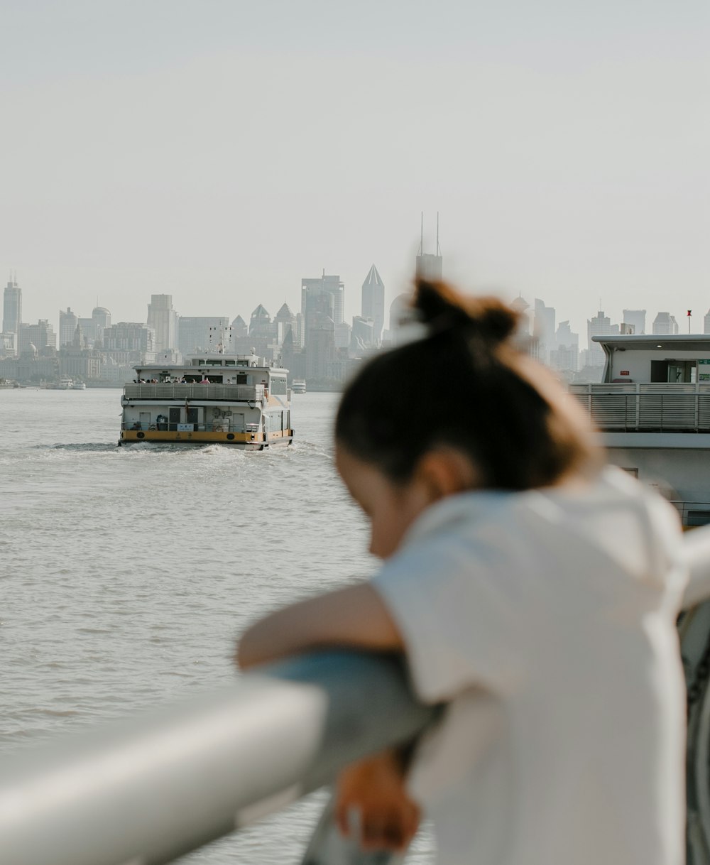 woman in white shirt looking at the sea during daytime