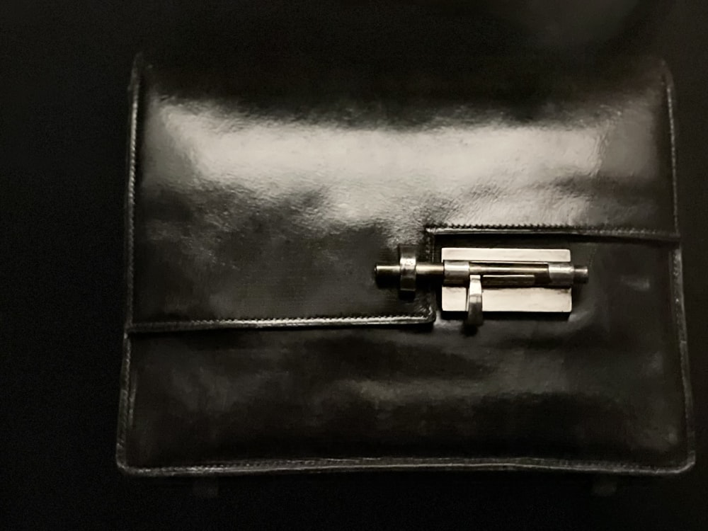 black leather bag with silver and black device