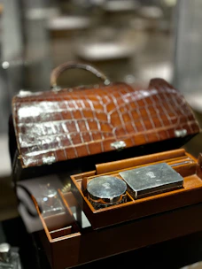 Luxurious leather toiletry bag open to reveal neatly organized compartments.