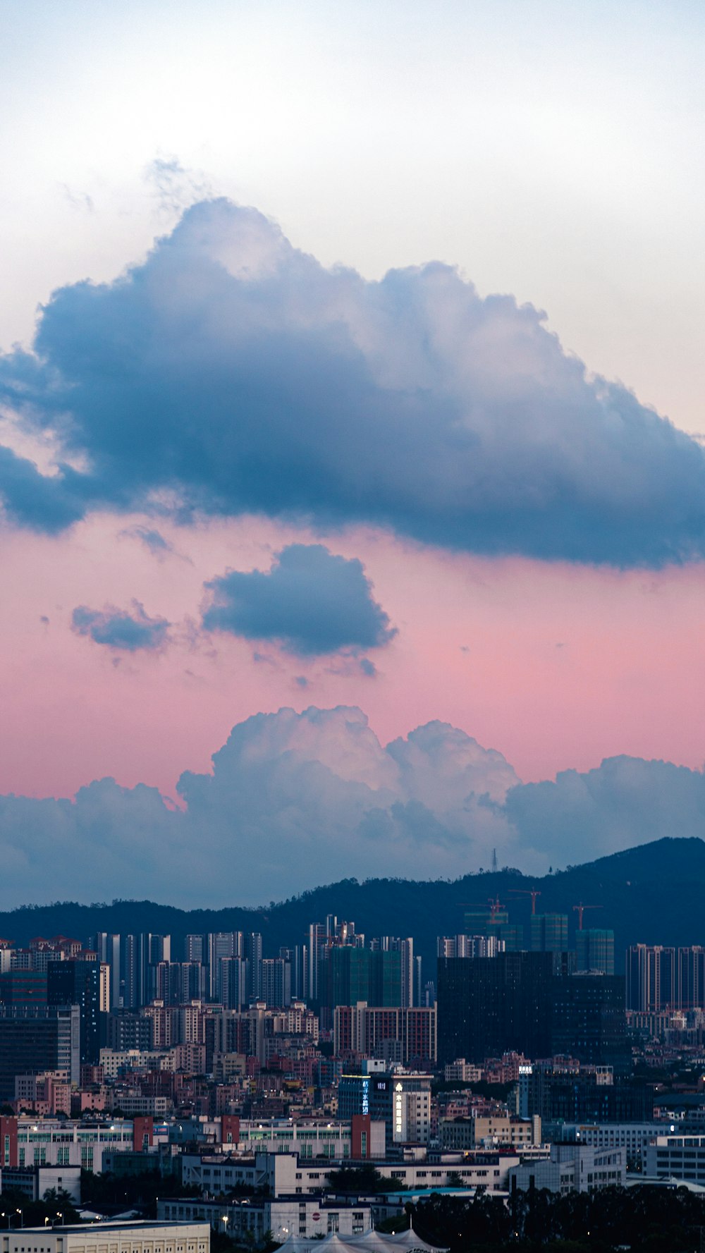 white clouds over city buildings during daytime