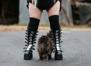 woman in black and white long sleeve shirt and black leggings wearing black boots walking on with on with on