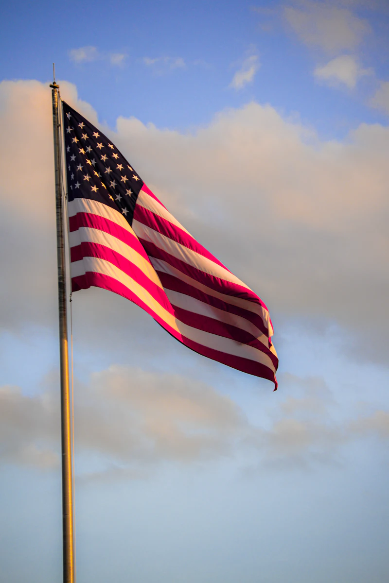 Worn American flag against a stone monument