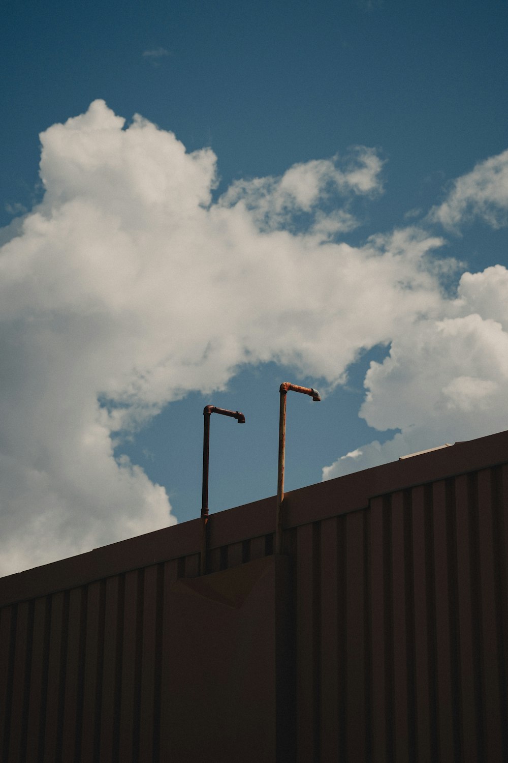 gray metal post under white clouds during daytime