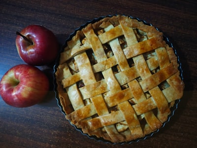 red apple beside brown pie apple pie teams background