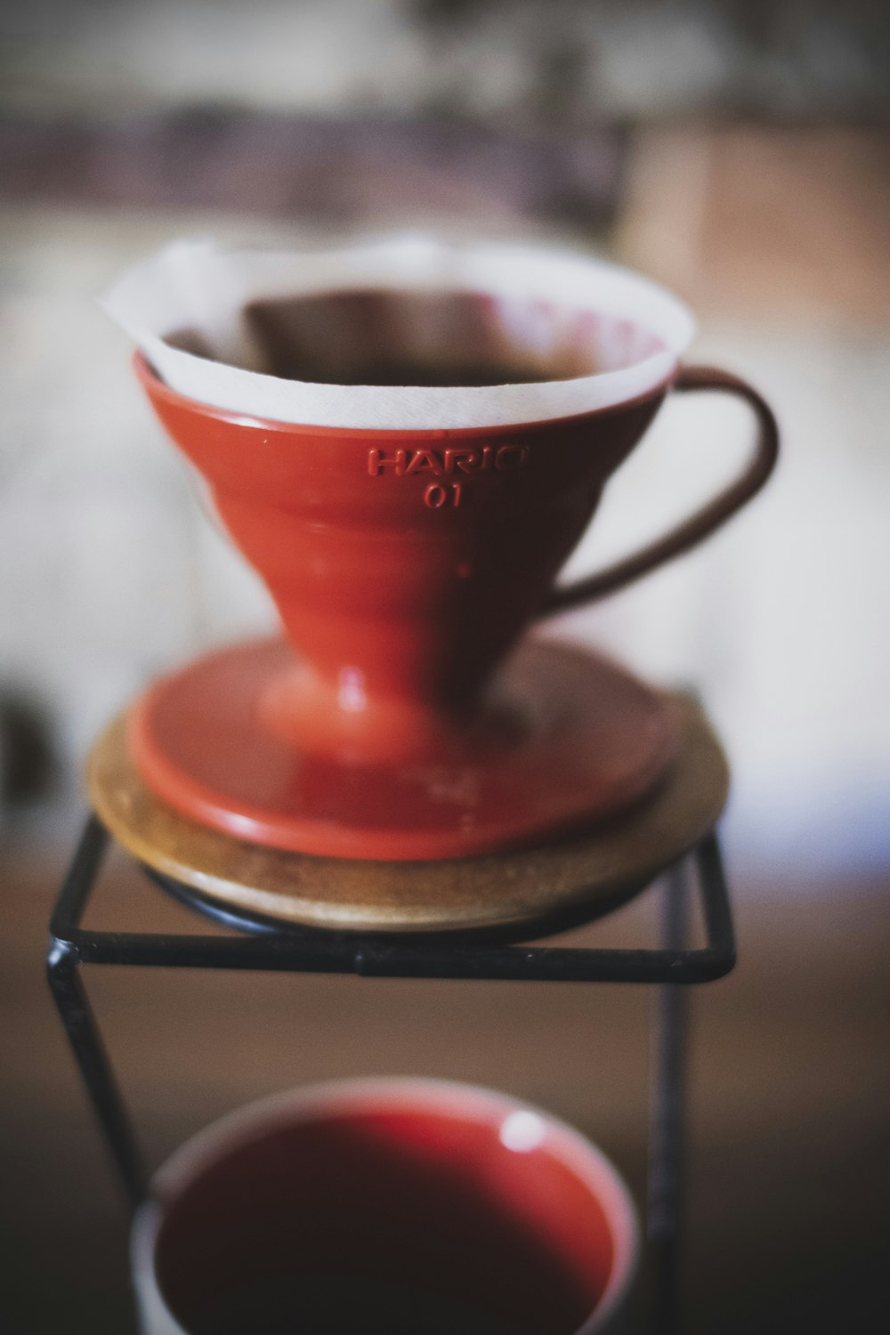 red and white ceramic cup on black metal rack