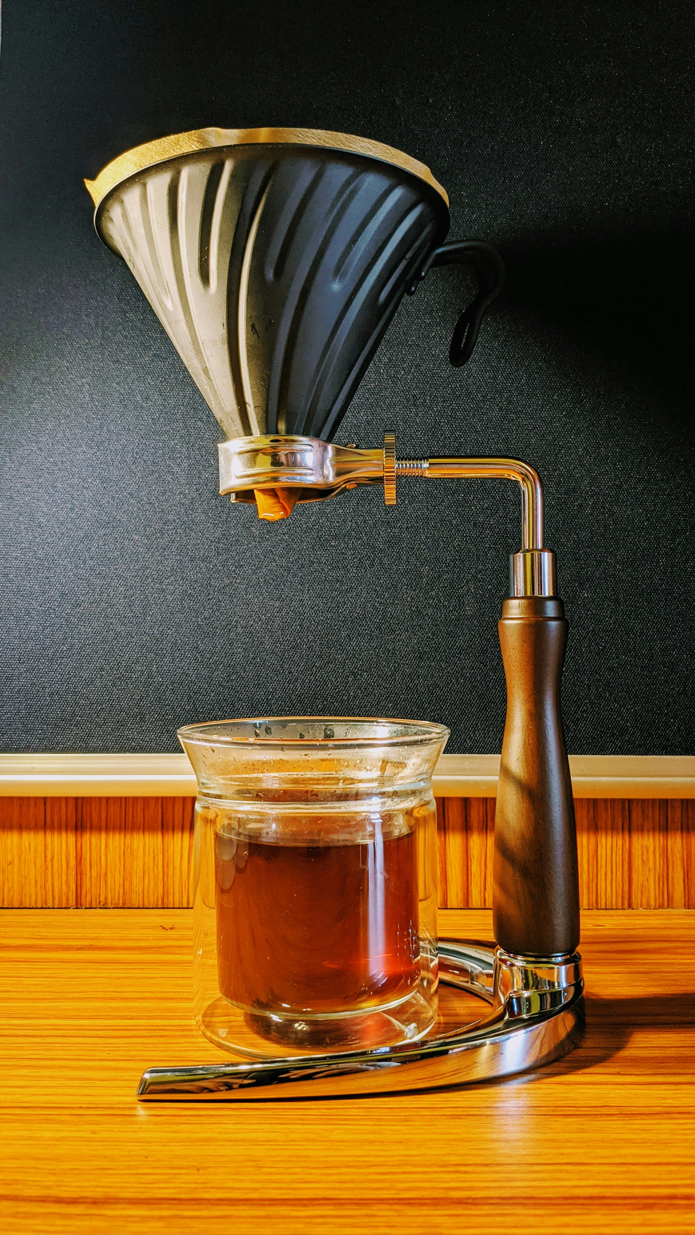 Pour-over coffee being brewed, steam rising, warm ceramic cup, minimal background