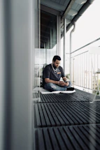 Modern glass balcony with a sleek smartphone displaying a WhatsApp chat interface