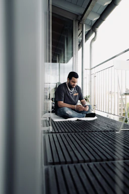 Modern glass balcony with a sleek smartphone displaying a WhatsApp chat interface