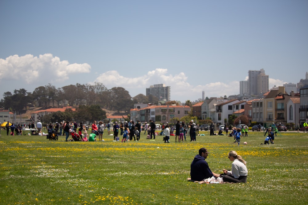 people sitting on green grass field during daytime