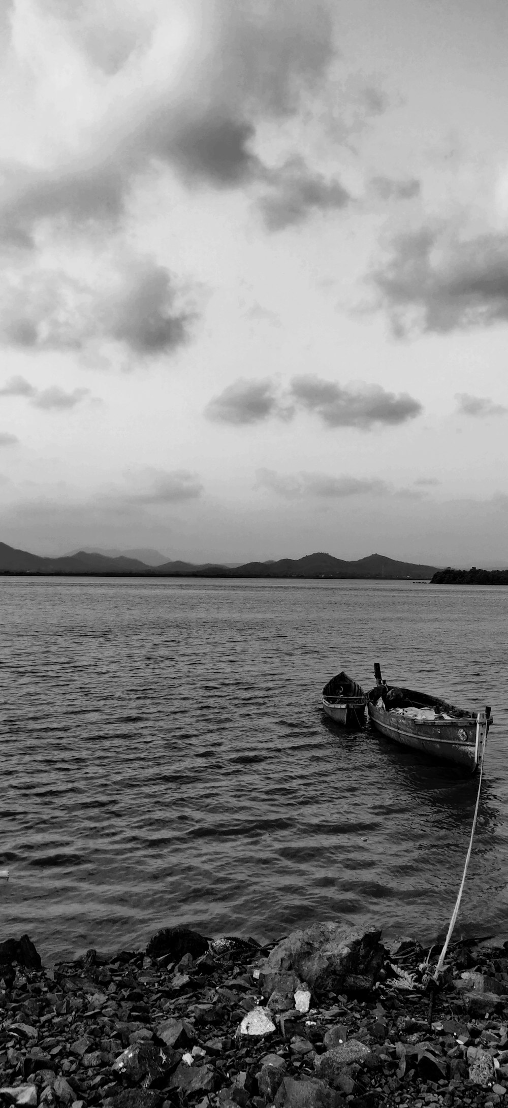 grayscale photo of man riding on boat on sea