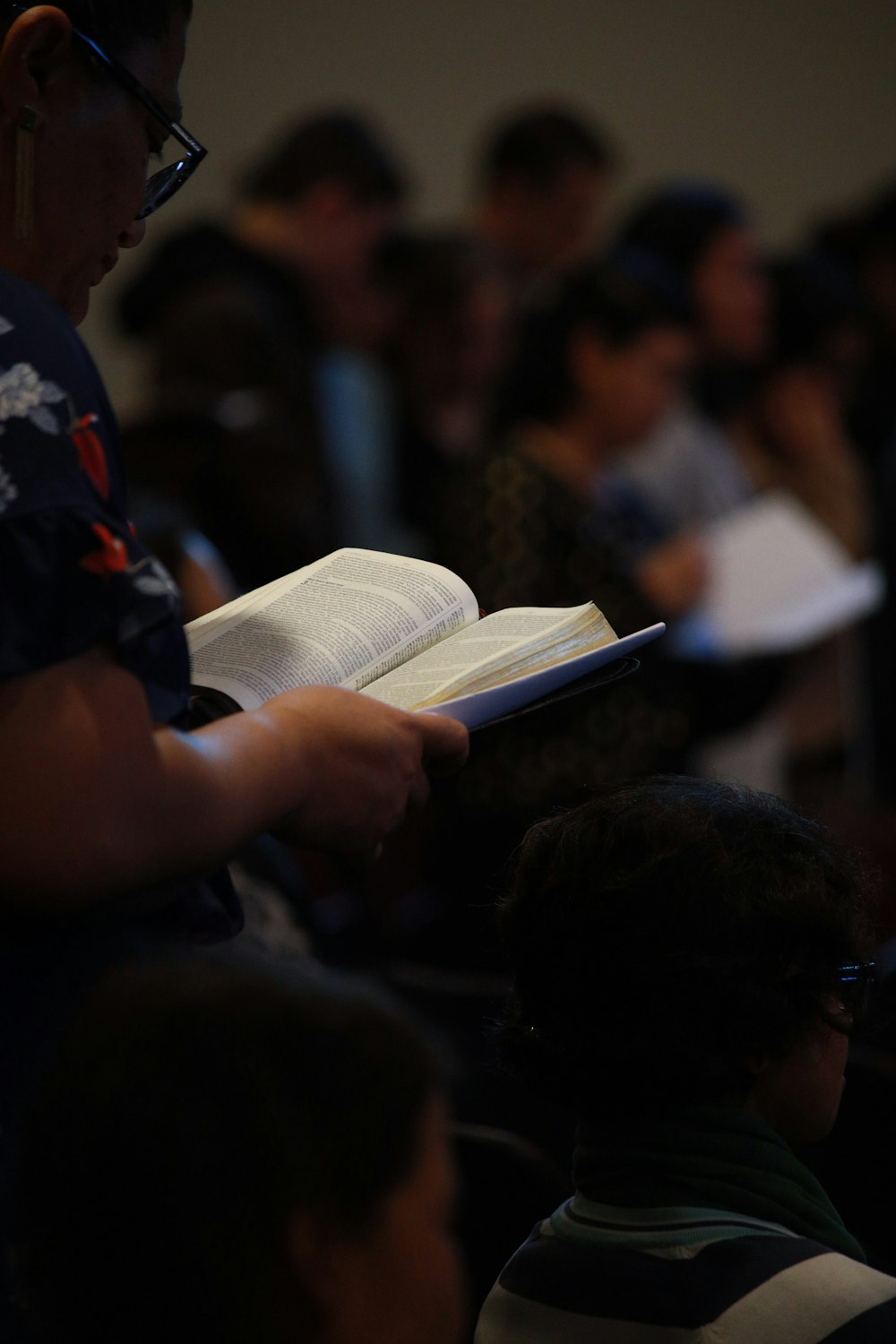 Hombre con camisa negra y roja leyendo un libro