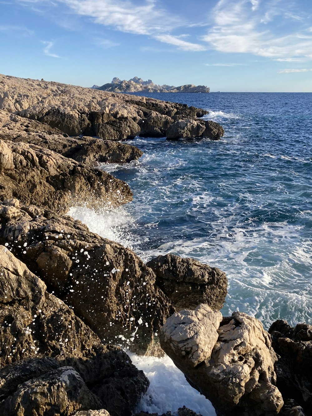 brown rocky shore with ocean waves during daytime