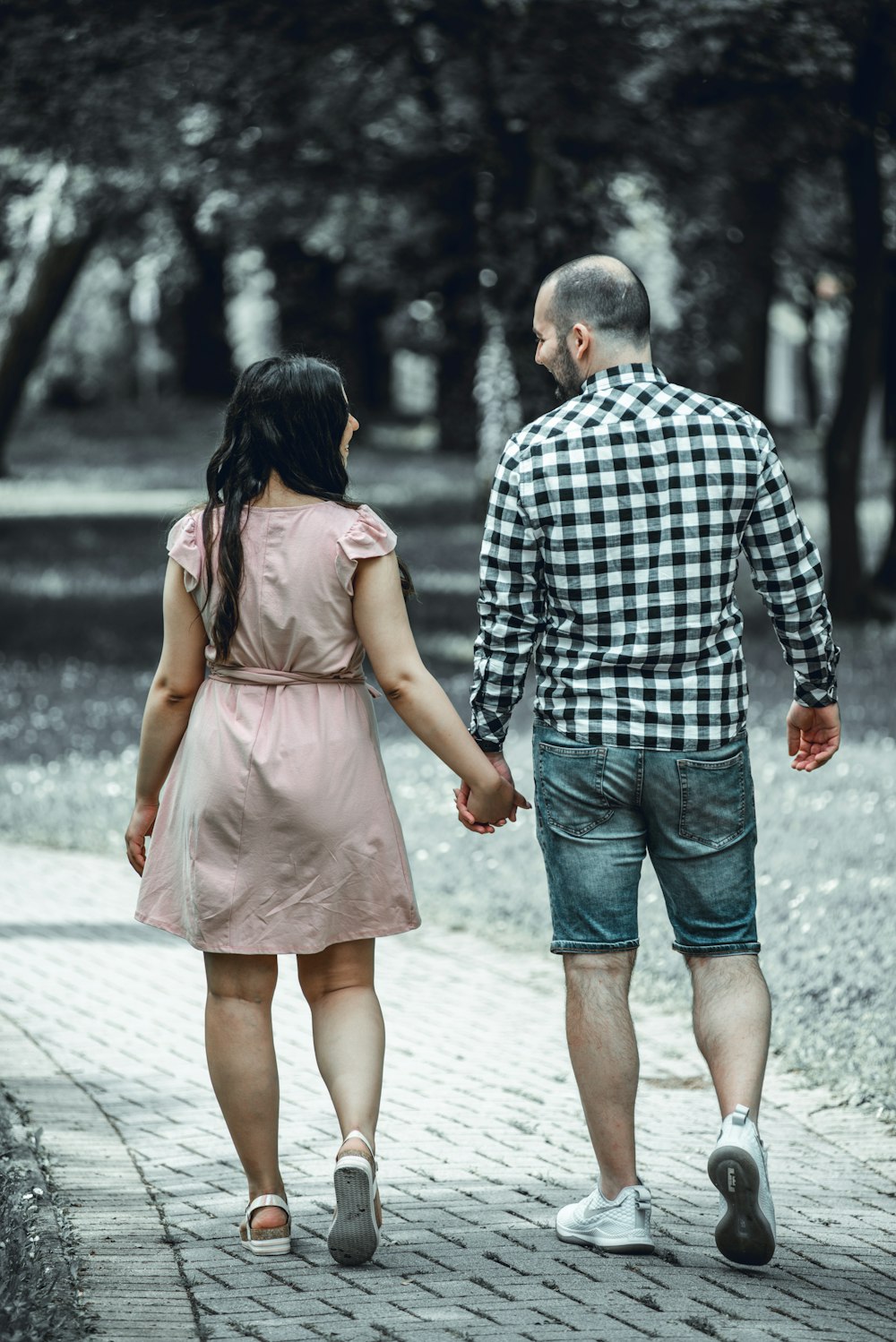 hombre y mujer caminando en la acera durante el día