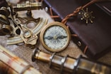 silver and gold compass on black leather textile