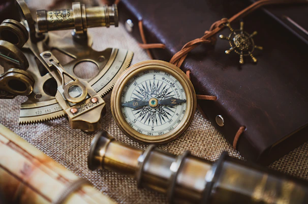 Nautical instruments displayed against a backdrop of vintage maps and wood.