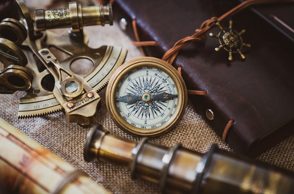 silver and gold compass on black leather textile