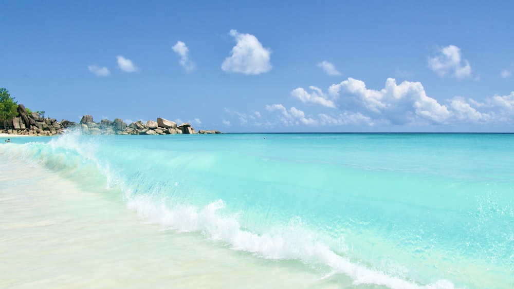 sea waves crashing on shore during daytime