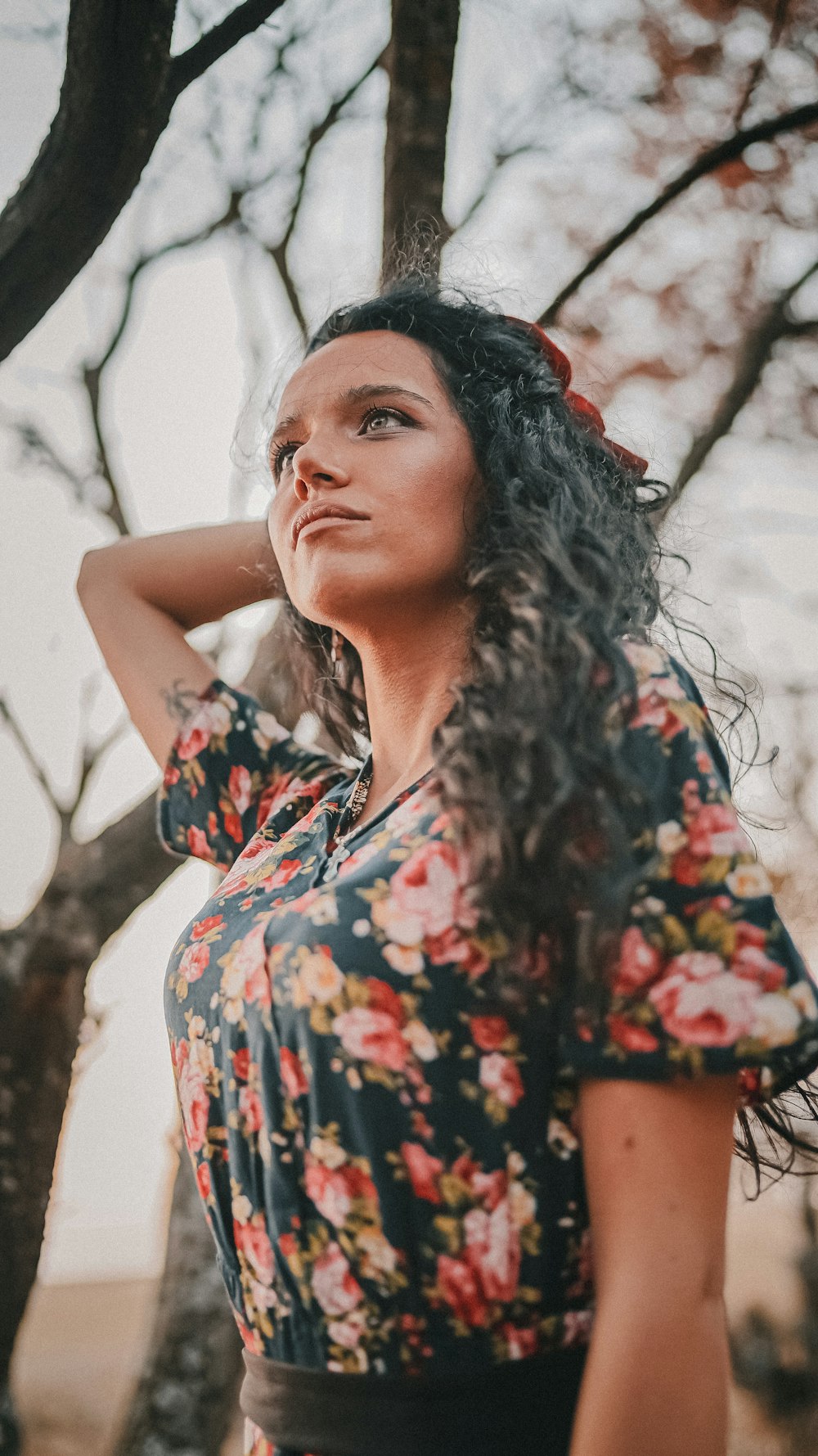 mujer con vestido floral negro, rojo y verde