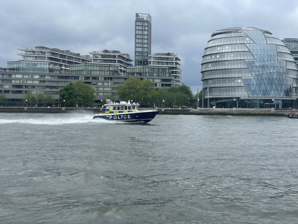 white and blue boat on water near city buildings during daytime