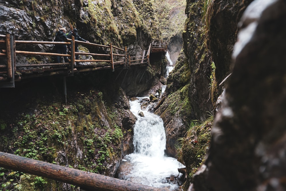 brown wooden bridge over water falls