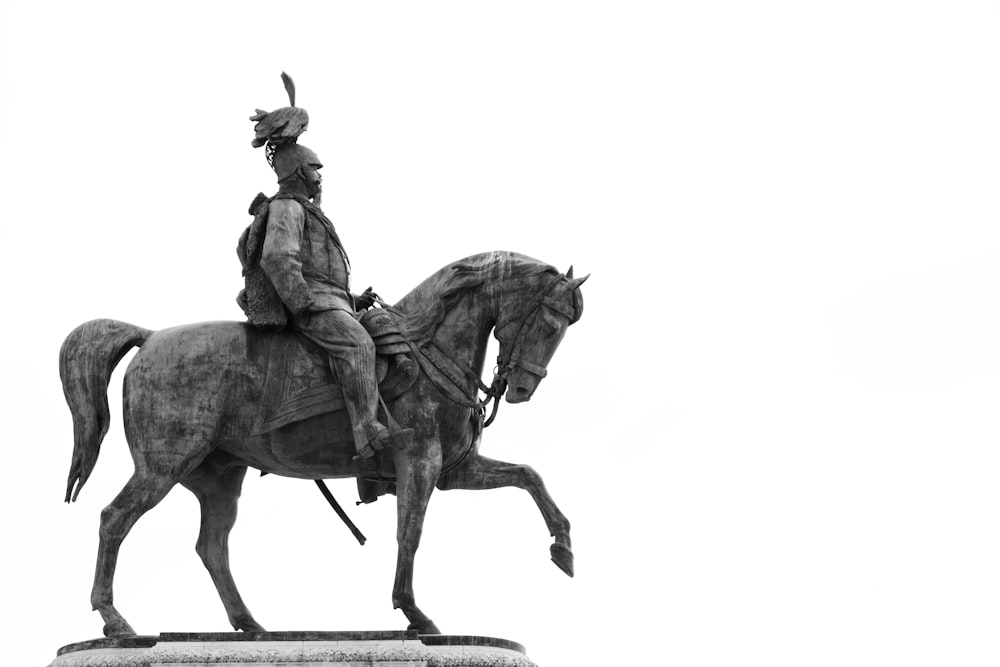 Una foto in bianco e nero di una statua di un uomo su un cavallo