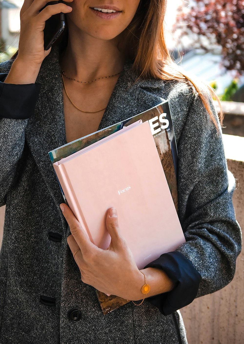 woman in gray cardigan holding white book