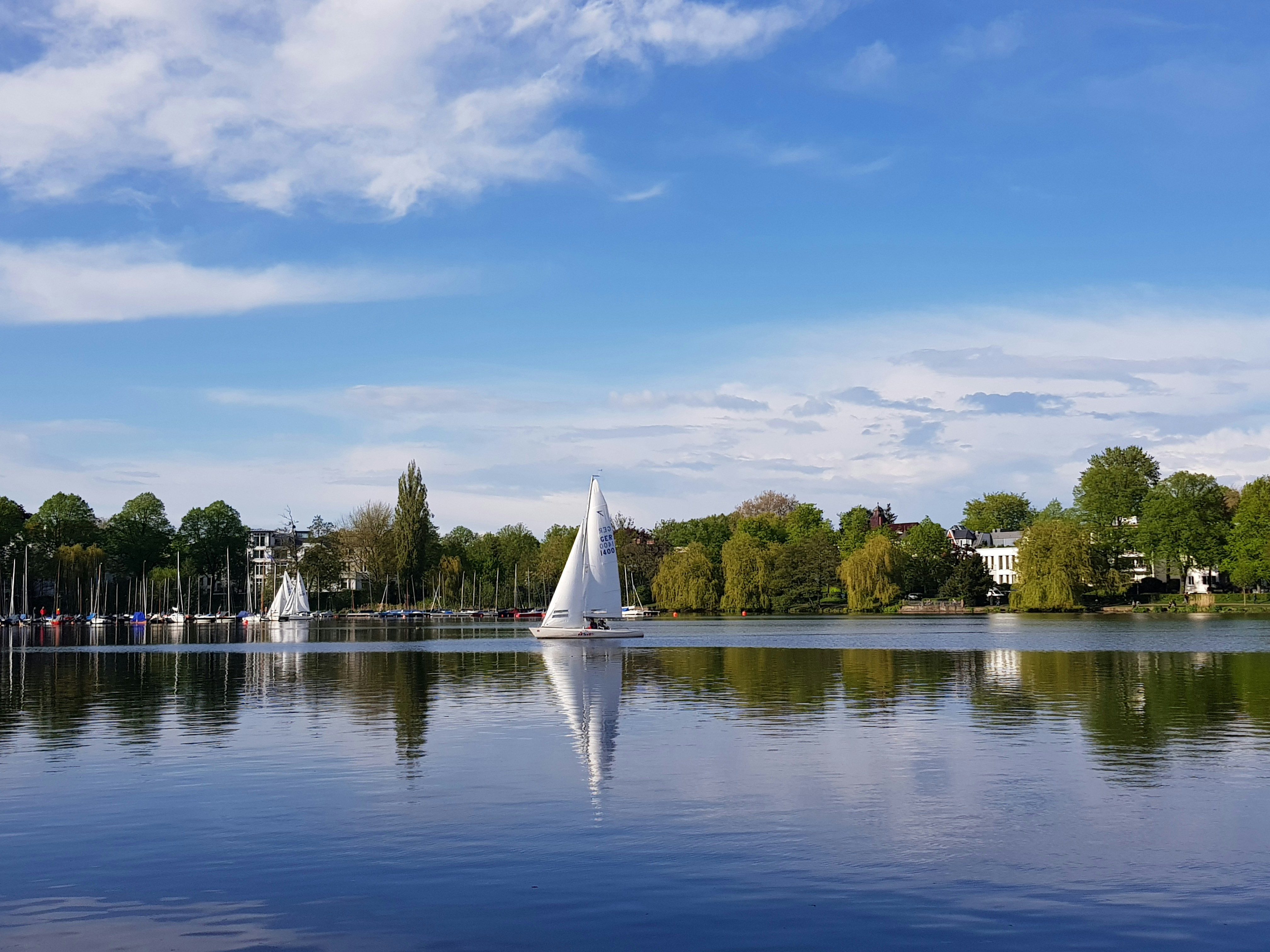 veleiro branco no lago sob o céu azul durante o dia